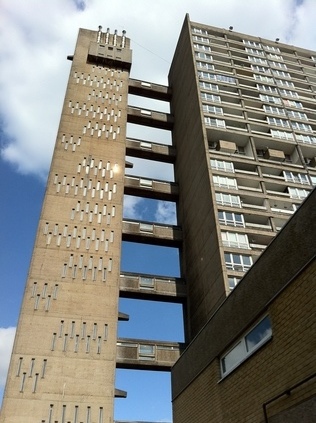 The slender service tower looks out of scale with the bulky building