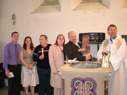 Godparents, family and vicar at the font